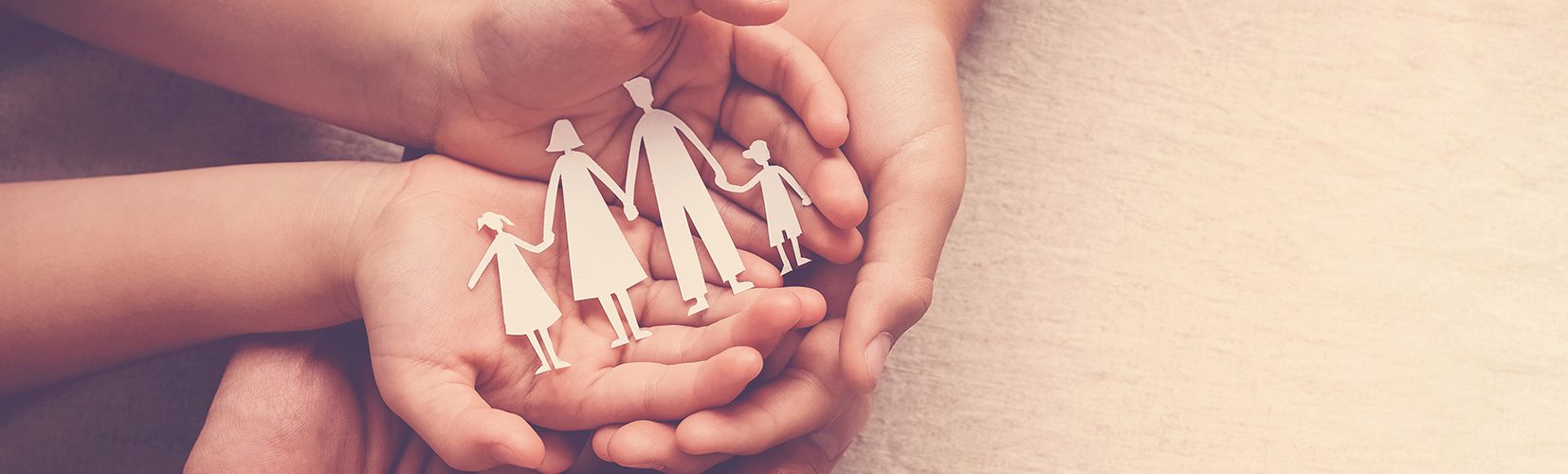 Bild Quelle: AdobeStock_282163930_©sewcream _hands holding paper family cutout, family home,life insurance, adoption foster care