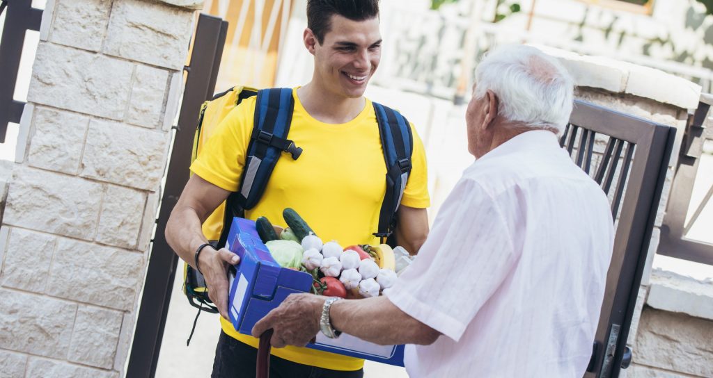 Foto:AdobeStock_441360578_©Mediterano_Young male volunteer delivering shopping to senior man
