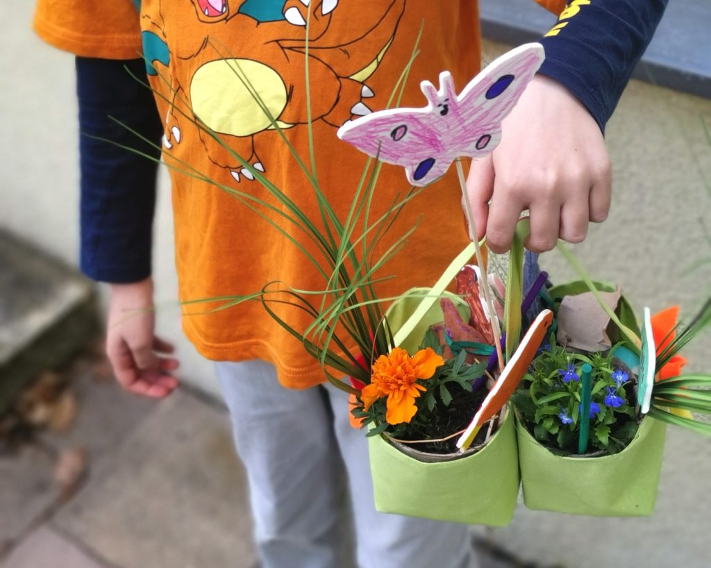 Oster Event im FAZ Fennpfuhl, Kind hält en Osterkörbchen mit Blumen und Dekostecker, der selbst gebastelt ist