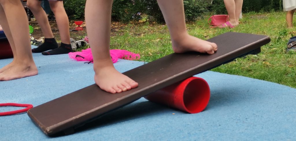 FAZ Fennpfuhl Zirkusnachmittag, Kinderfuesse balanciert auf Rolle mit einem Brett