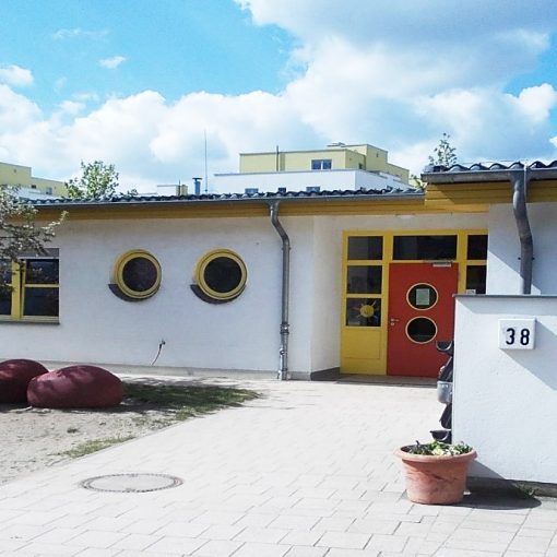 Kita_Sonnenkinder, Eingang der Kitas mit roter Tür und runden Fenstern