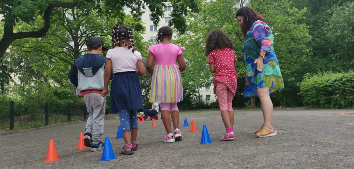 Nachbarschaftsfest im Margaretentreff, Kinder malen und soielen vor dem Treff und Nachbarn plaudern am Tisch