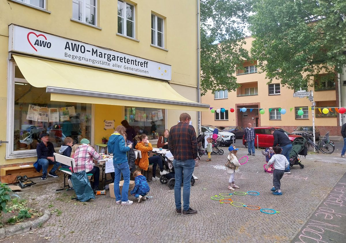 Nachbarschaftsfest im Margaretentreff, Kinder malen und soielen vor dem Treff und Nachbarn plaudern am Tisch