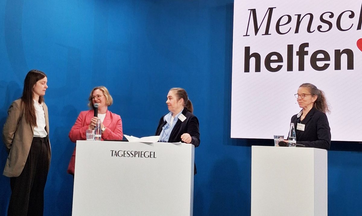 Mitarbeiter vom MARIE Engagementbüro stehen am Rednerpult und stellen das Projekt vor, Tagesspiegel Spendengala